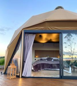 ランショ・ケイマードにあるKairos Glamping - Rancho Queimado - SCのベッド1台が備わる大型テントです。