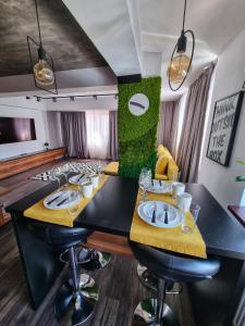 a dining room with two tables with yellow cushioned chairs at Eclipsei ApartHotel in Popeşti-Leordeni