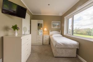 a bedroom with two beds and a flat screen tv at Lios Na Manach ECO B&B in Killarney