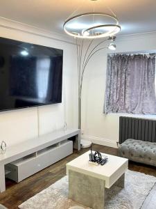 a living room with a large television and a couch at Spacious 4 bedroom house in Billericay