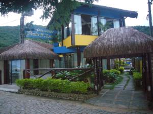 un edificio con sombrillas de paja frente a una calle en Pousada Praia D'Azul, en Abraão