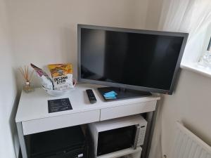 een tv zittend op een wit bureau met een televisie bij CeCe's in Gurnard