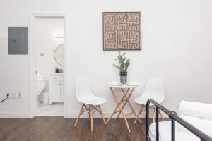 a white living room with two white chairs and a table at Miami Downtown Cozy Studio near to South Beach - 5 minutes to Wynwood in Miami