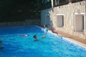two girls playing with a frisbee in a swimming pool at Residence Miralago Rooms & Apartments in Manerba del Garda