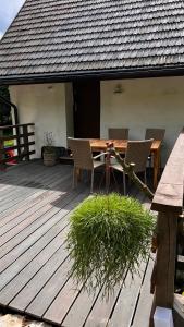 een houten terras met een tafel en stoelen erop bij Apartamenty 3 Pory Roku Lato in Komarno