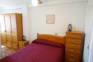 a bedroom with a bed and a dresser at Gran apartamento en primera línea Motril in Motril