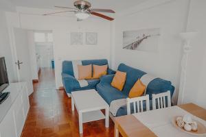 a living room with a blue couch and a table at Gran apartamento en primera línea Motril in Motril
