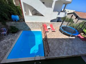 uma vista sobre uma piscina com 2 cadeiras e um baloiço em House with pool and sea view em Bar