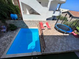 an overhead view of a swimming pool with two chairs and a swing at House with pool and sea view in Bar