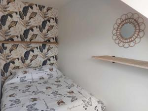 ein Schlafzimmer mit einem Bett mit einem Kissen und einem Regal in der Unterkunft Gite Comme chez soi in Spa
