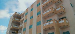 a building with balconies on the side of it at عمارة الحج موسي بشاطئ أم الرخم عجيبه in Zâwyet Umm el Rakham