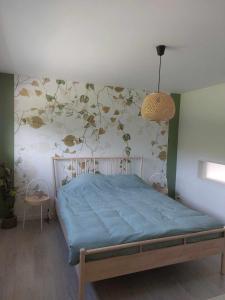 1 dormitorio con 1 cama con pared de flores en Gite Comme chez soi en Spa