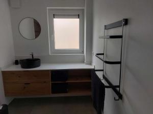 un bagno con specchio, cassettiera e finestra di Gite Comme chez soi a Spa