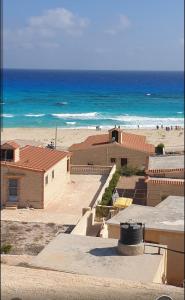 a view of a beach with buildings and the ocean at عمارة الحج موسي بشاطئ أم الرخم عجيبه in Zâwyet Umm el Rakham