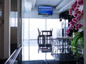a dining room with a table and chairs and a tv at PATONG TOWER FAMILY APARTMENT by PTA in Patong Beach