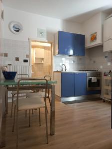 een keuken met blauwe kasten en een tafel met stoelen bij Apartment Cafoscari in Venetië
