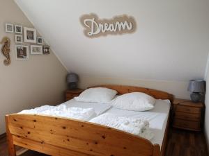 ノルトダイヒにあるFerienwohnung Riedefixのベッドルーム1室(白いシーツが備わる木製ベッド1台付)