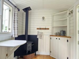 a kitchen with a wood stove in a room at Craskie Glamping Pods in Inverness