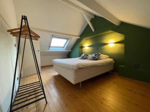 une chambre verte avec un lit et une échelle dans l'établissement Het Zwaluwnest, à Middelkerke