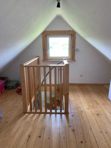 Cette chambre dispose d'un escalier en bois et d'une fenêtre. dans l'établissement Domek wypoczynkowy Sosenkowo, à Suwałki