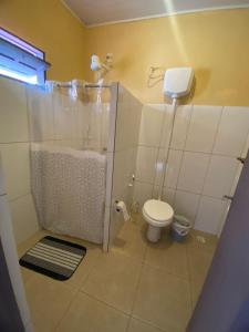 a small bathroom with a shower and a toilet at Casinha Temporada Itaúnas in Itaúnas