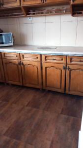 a kitchen with wooden cabinets and a counter top at CASA ADELA in Tulcea