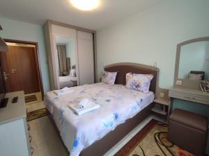 a small bedroom with a bed with a mirror at Кай Apartment's Sarafovo in Burgas