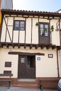 - Edificio con puerta de madera y balcón en La casa de la abuela Amalia, en Arenas de San Pedro