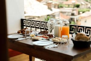 a table with breakfast food and orange juice on it at Hotel Sarajet 1821 in Gjirokastër