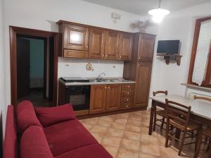 een woonkamer met een bank en een keuken bij Il Colombaiolo in Castelmuzio