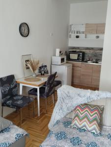 a living room with a table and chairs and a kitchen at Apartman (stan na dan) M&M Prijedor in Prijedor