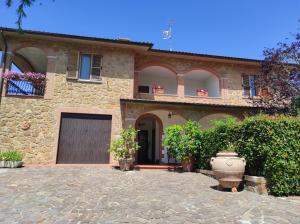 uma grande casa de pedra com garagem e quintal em Il Colombaiolo em Castelmuzio