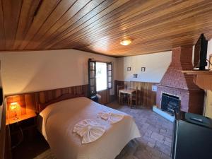 a bedroom with a bed and a fireplace at Banyvas Chalés in Monte Verde