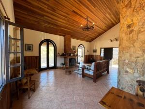 een grote woonkamer met een houten plafond bij Banyvas Chalés in Monte Verde