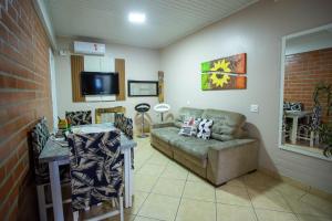 Una sala de estar con un sofá y un televisor. en Lar do Vale - Vinhedos, en Bento Gonçalves