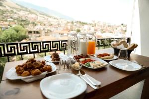 a table with plates of food and a view of a city at Hotel Sarajet 1821 in Gjirokastër