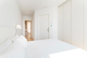 a white bedroom with a white bed and white cabinets at Porto Real Hotel in Finisterre