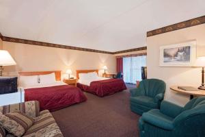 a hotel room with two beds and a couch at Ramada by Wyndham Pinewood Park Resort North Bay in North Bay +33 photos