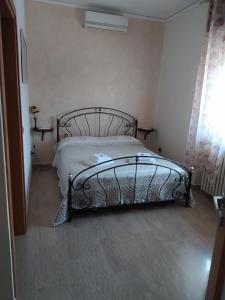 um quarto com uma cama de metal num quarto em Villa Rita em Monzambano