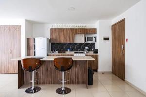 eine Küche mit einer Theke und 2 Barhockern in der Unterkunft Apartment, renovated perfect for Nomads in Mexiko-Stadt