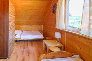 Habitación con 2 camas en una cabaña de madera en DOMKI ANITA, en Zawóz