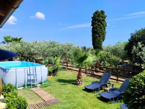 einen Garten mit einer Badewanne, Stühlen und Bäumen in der Unterkunft Casa Vacanze 'Al Giardino degli Ulivi' in Marinella di Selinunte
