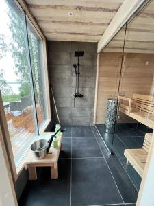 uma sauna com uma banheira e um lavatório num quarto em Lake Cottage with sauna (near City) em Jyväskylä