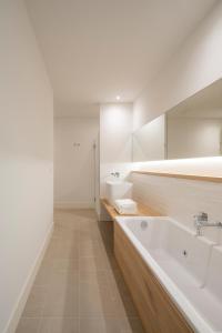 a white bathroom with a tub and a sink at Porto Real Hotel in Finisterre