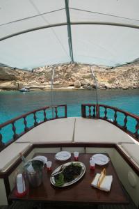 a table with a plate of food on a boat at El Mosaico Del Sol in Lampedusa