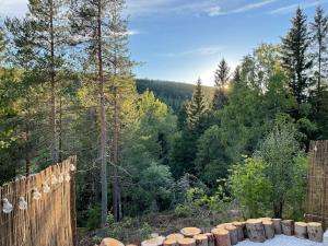 a view of a forest with a fence and trees at Hadeland Cottage in Lunner