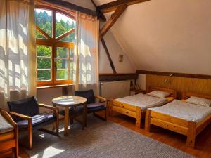 Habitación con 2 camas, mesa y ventana en Agro - Dom Wsrod Lasow en Trzcianka