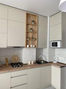 a kitchen with white cabinets and a counter top at Apartments LUNA in K'obulet'i