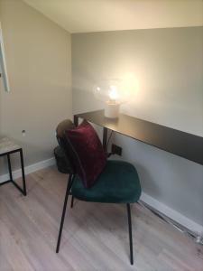 um quarto com uma cadeira e uma mesa com um candeeiro em Live Attic room em Somma Vesuviana