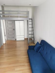a living room with a blue couch and a bunk bed at Town Square Apartment in Lublin